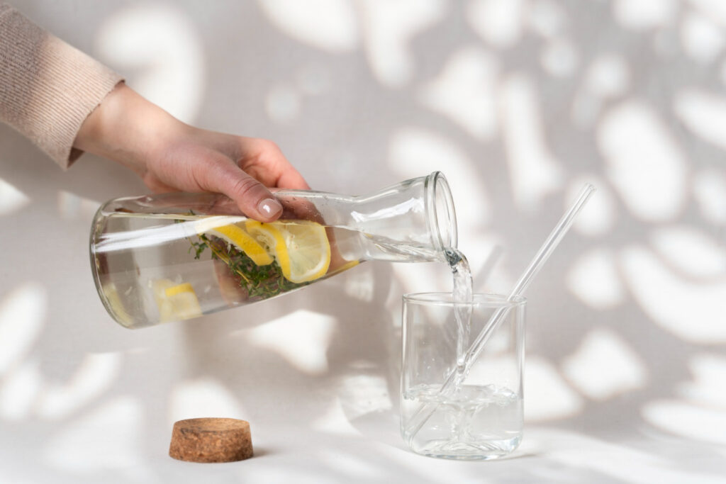 Bicchiere d’acqua appoggiato su un tavolo illuminato dalla luce del mattino