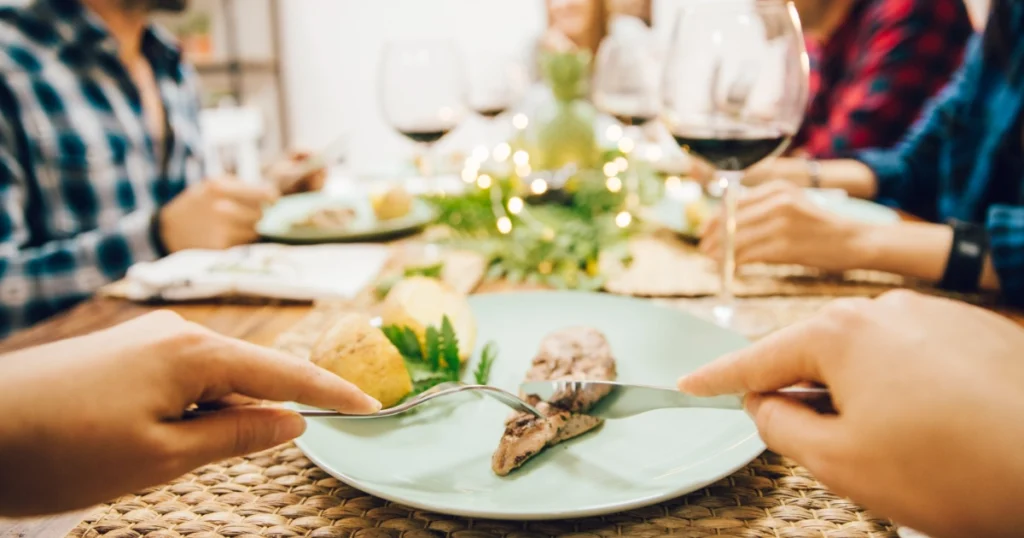 Famiglia seduta a tavola durante un pranzo festivo in un’atmosfera rilassata